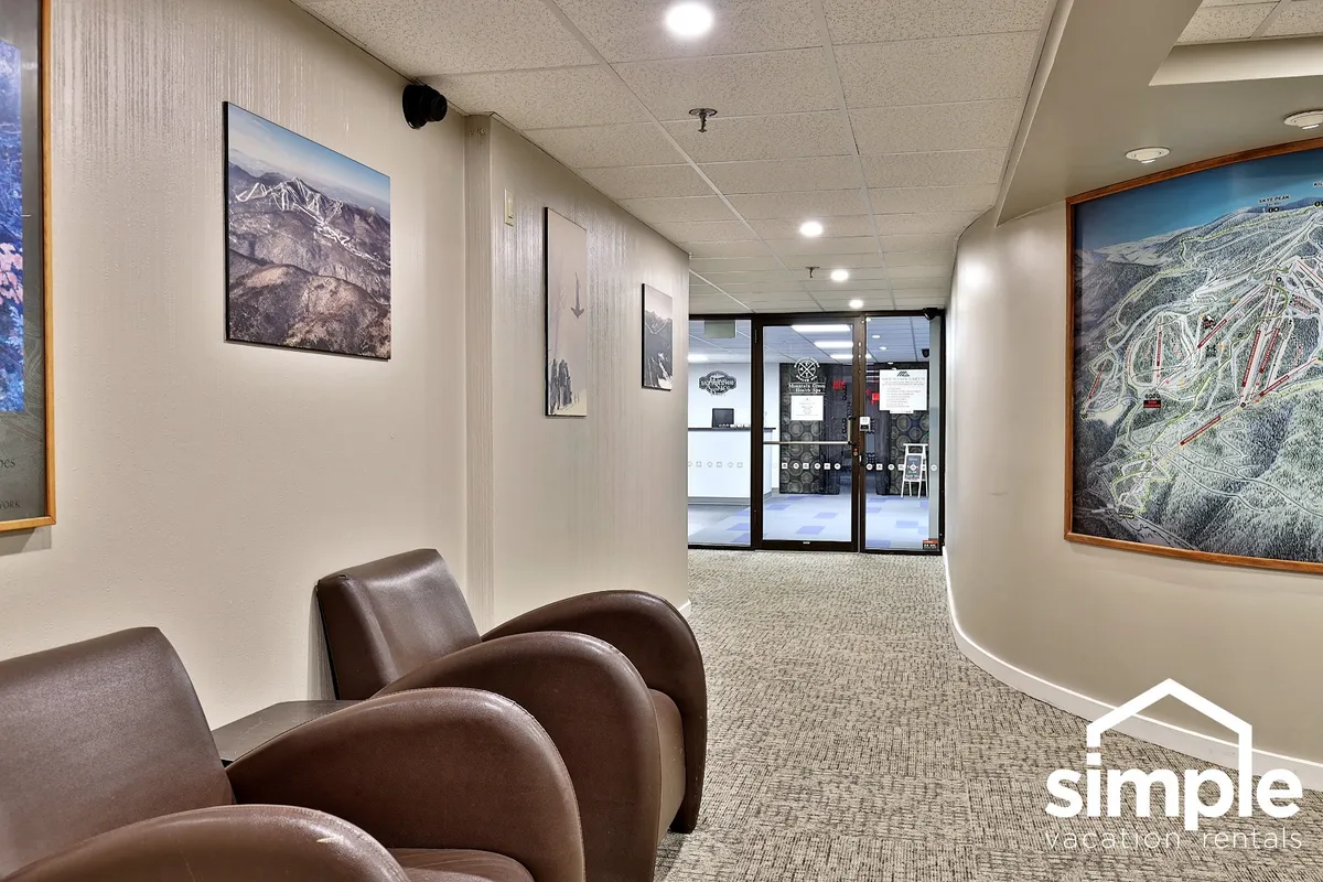 A welcoming seating area with inviting chairs, colorful artwork, and the visible entrance to another space, creating an atmosphere that encourages relaxation and socializing before or after local adventures.