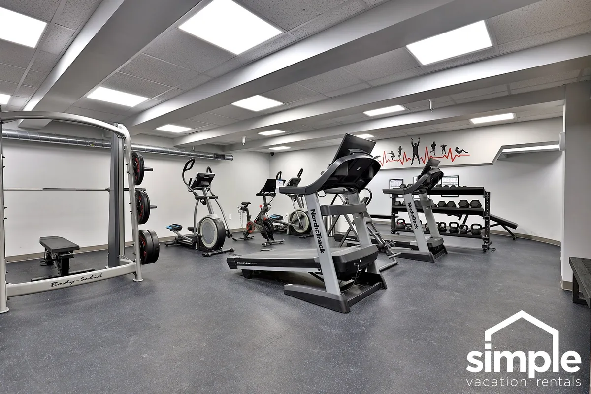 A modern fitness center filled with weightlifting equipment, cardio machines, and exercise mats. The room is spacious and well-organized, encouraging both individual workouts and group classes.