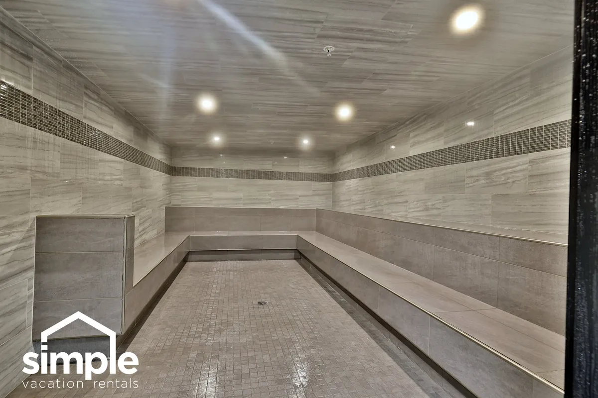 A tranquil wellness area with smooth marble walls, spacious seating, and warm ambient lighting, suggesting a soothing and rejuvenating environment for relaxation after a day out.