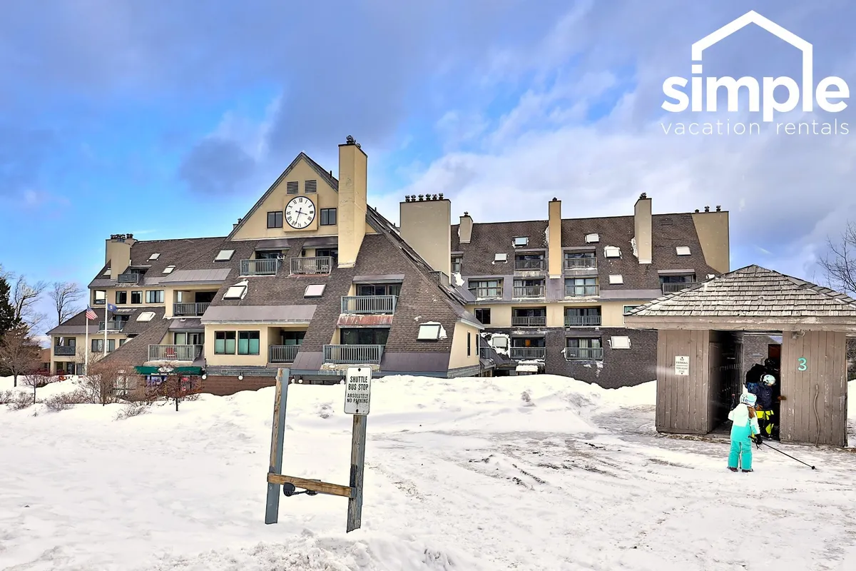 An exterior shot of the building’s welcoming architecture, featuring a large clock and entryway, surrounded by snowy scenery. The setting feels warm and approachable, inviting guests back from their adventures.